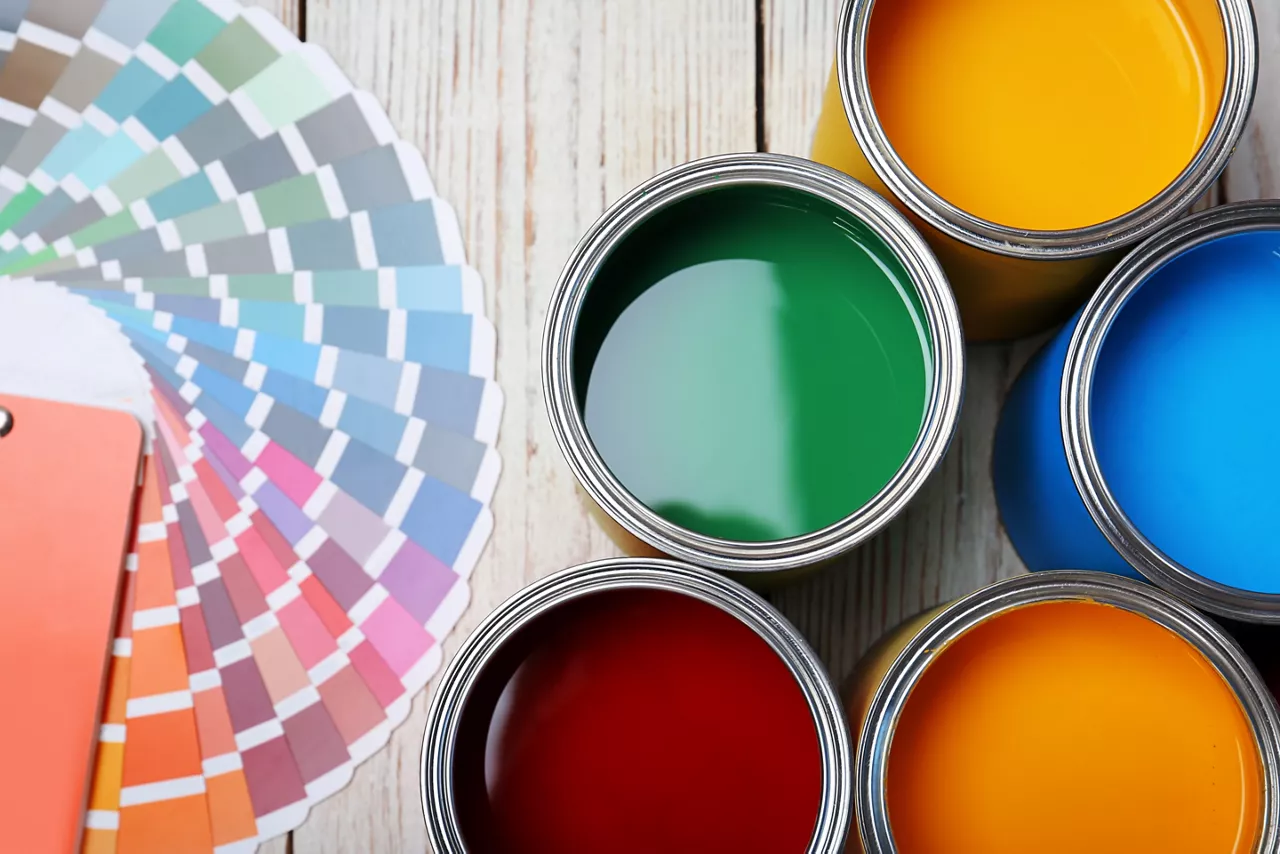 Cans with paint and color palette on wooden background, top view 