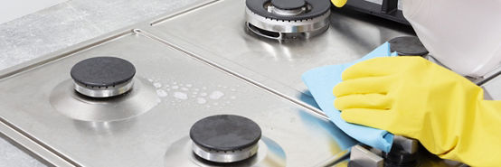 Cleaning a gas stove with kitchen utensils, household concepts, or hygiene and cleaning