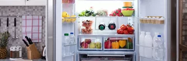 An Open Refrigerator Filled With Fresh Fruits And Vegetables