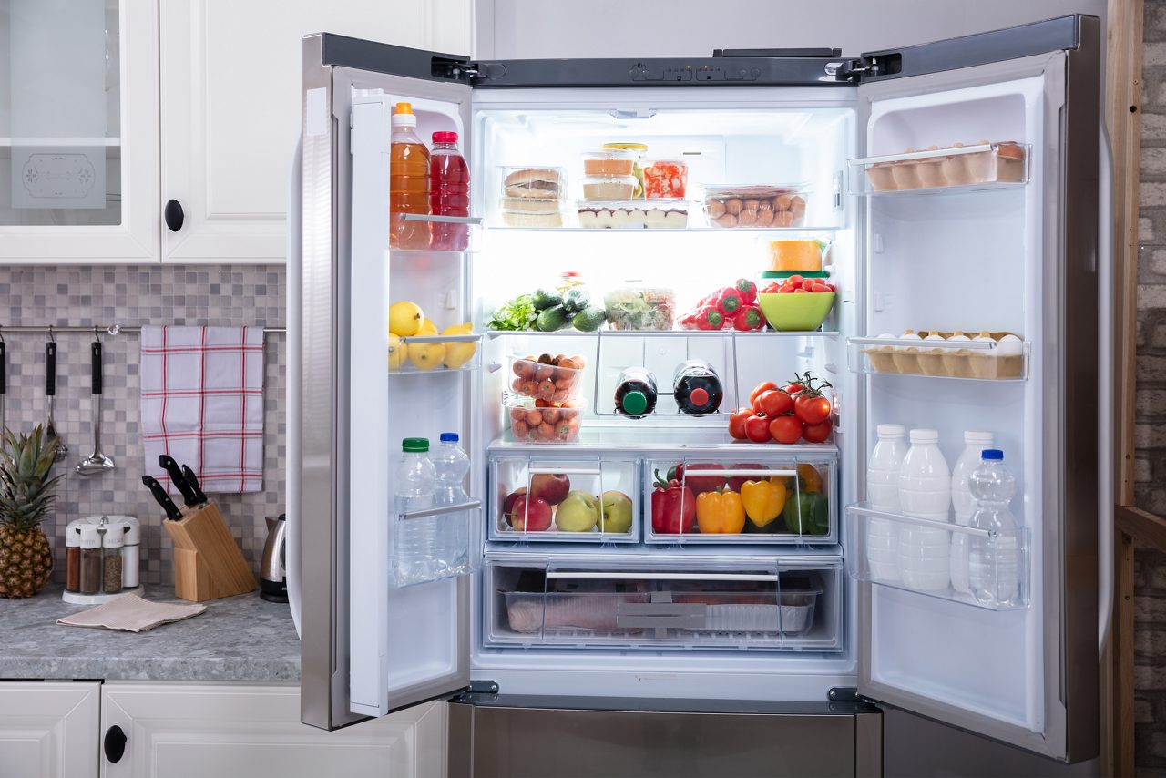 Un refrigerador abierto lleno de frutas y verduras frescas