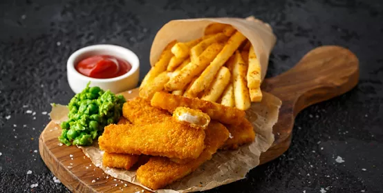 Fast food in paper displayed on a wooden board