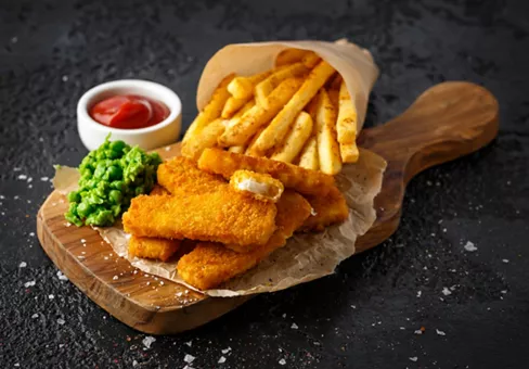 Fast food in paper displayed on a wooden board 