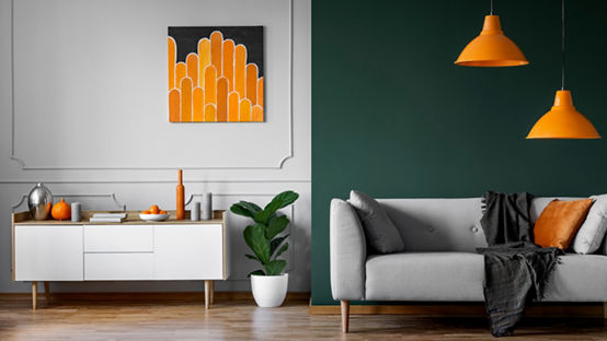 Abstract orange painting on grey wall of stylish living room interior