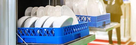 Pratos brancos na cesta na máquina de lavar louça automática industrial