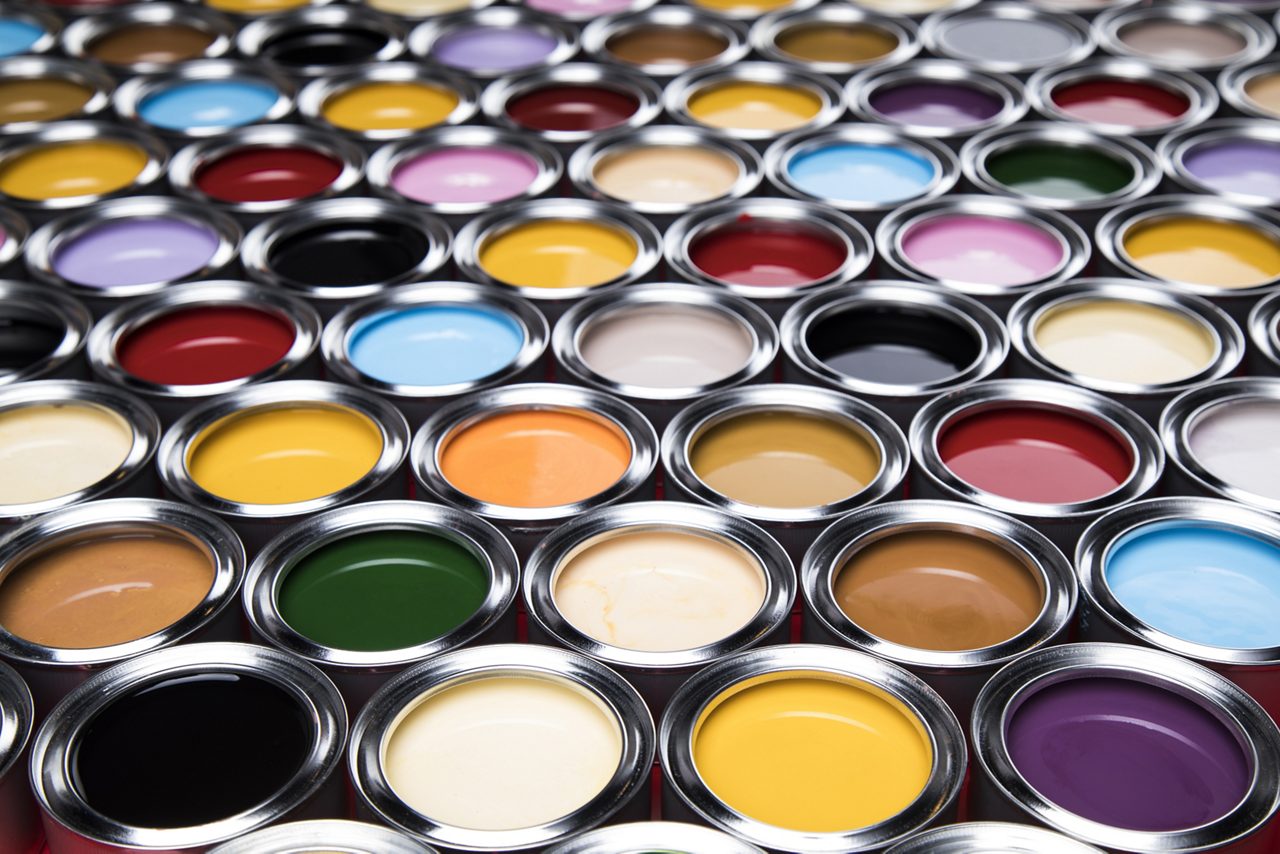Large array of open paint cans containing various colors of paint