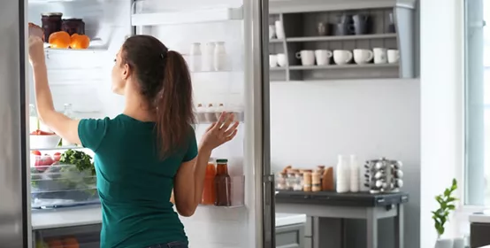 Woman grabbing food from fridge 