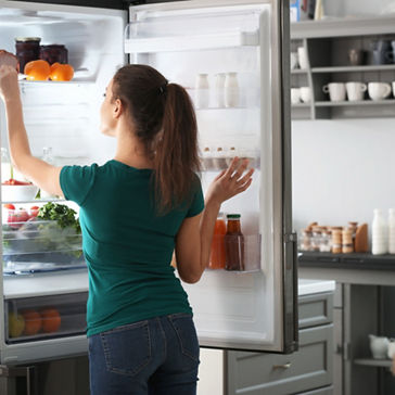 Woman taking food out of fridge at home Adobe Stock License 2020