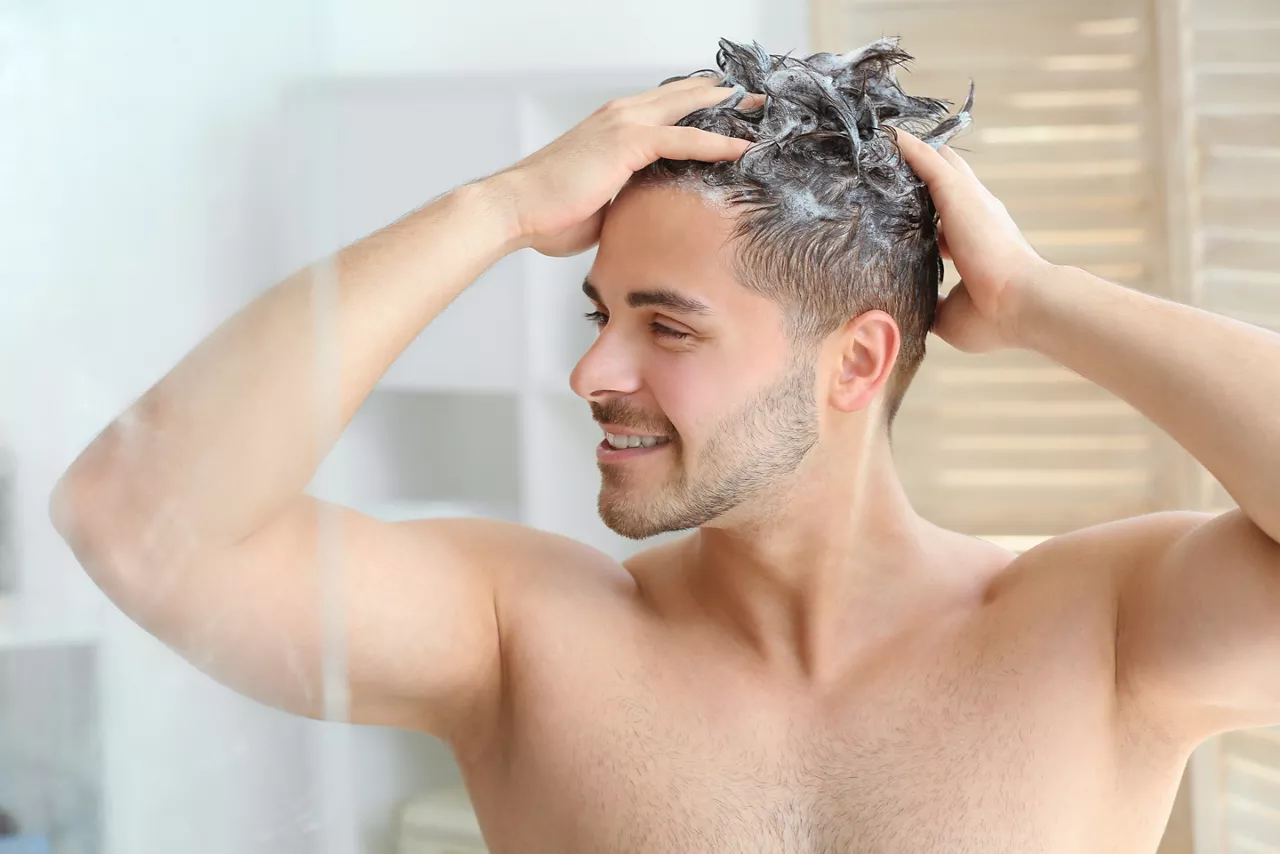 Man washing hair in bathroom