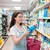 A young pretty woman chooses a cleaning agent in the store. Purchase and sale of goods in the store. Close up.