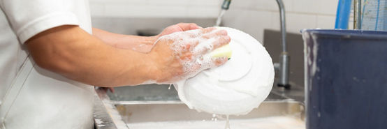 Homem lavando potes na pia