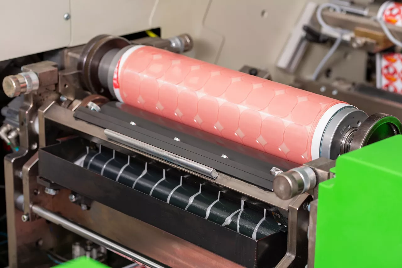 Flexographic machine with ink tray and varnish, ceramic anilox roll, doctor blade and a print cylinder with photopolymer. In-line press machine. Rotary or Flexo printing machine. Varnishing process.