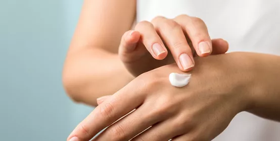 healthy hands and nails. seasonal skin protection. woman applying moisturizer on her hands.