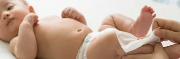 Mom cleaning up and wipe baby by wet tissue when changing diaper