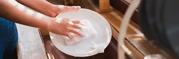 Person washing dishes in sink