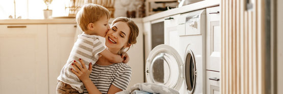Mother with son in front of laundry basket filled with linen