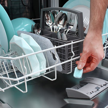 一位男士将平板电脑放入洗碗机清洗脏盘子