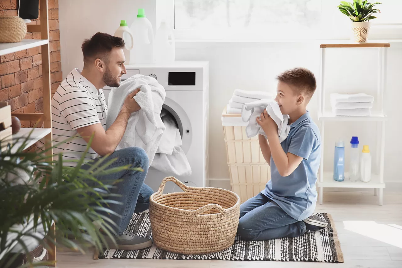 Father and son smelling clean laundry