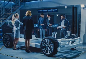 Business people standing around an electric car design