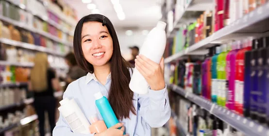 Fine Chinese woman buying hair care products in supermarket