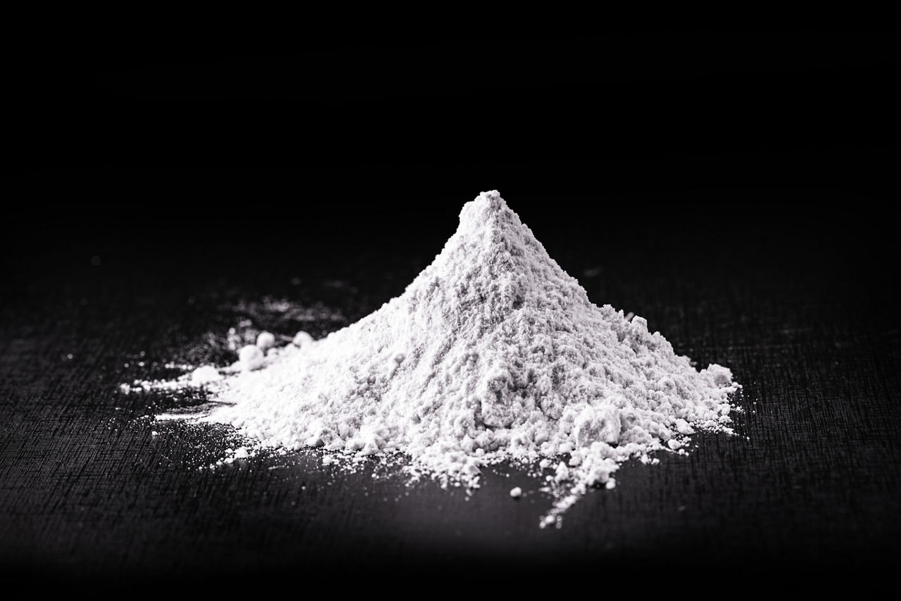 Closeup of redispersal latex powder in a clump against matt black background.