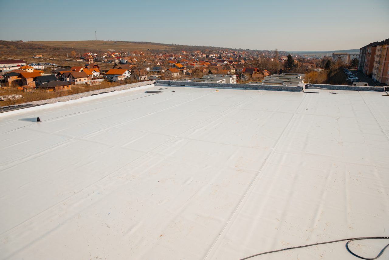 Flat roof with hot air welded PVC membrane waterproofing for ballasted system.