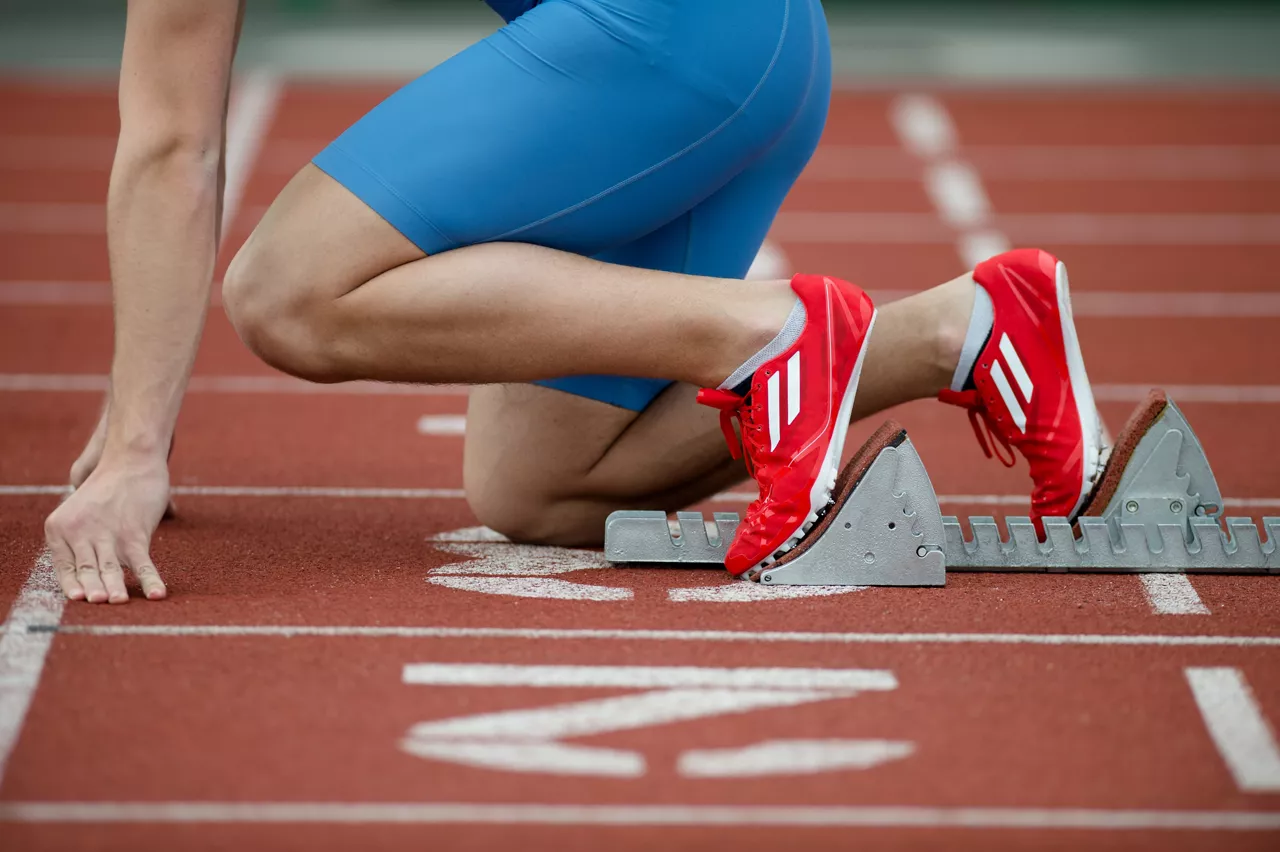 Detailed view of a sprinter in the starting blocks