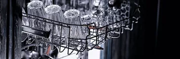 dishes in an open dishwasher, home style lifestyle, cleanliness and convenience background