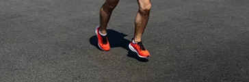 man in orange shoes running on dark road