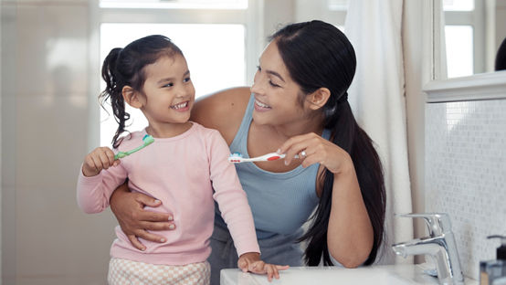 Madre e hija cepillando los dientes 