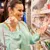 Smiling person selecting meat and cheese products from a cooler in the supermarket