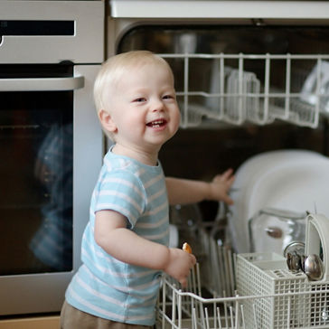 小孩子帮助从洗碗机中取出餐盘