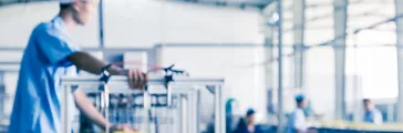 Production line of bottled drinks with man and other workers out of focus in background