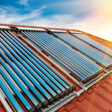 真空コレクタ - 家の赤い屋根の太陽熱温水システム