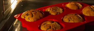 Close up of muffins baking in red silicon tray