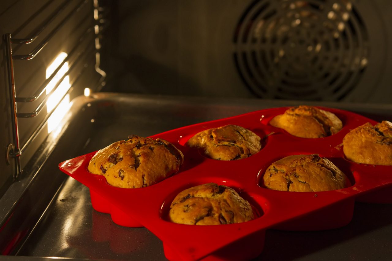 Close up of muffins baking in red silicon tray