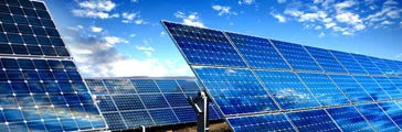 Rows of photovoltaic solar panels and blue sky with clouds