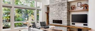 Living room with hardwood floors, fireplace, and large bank of windows