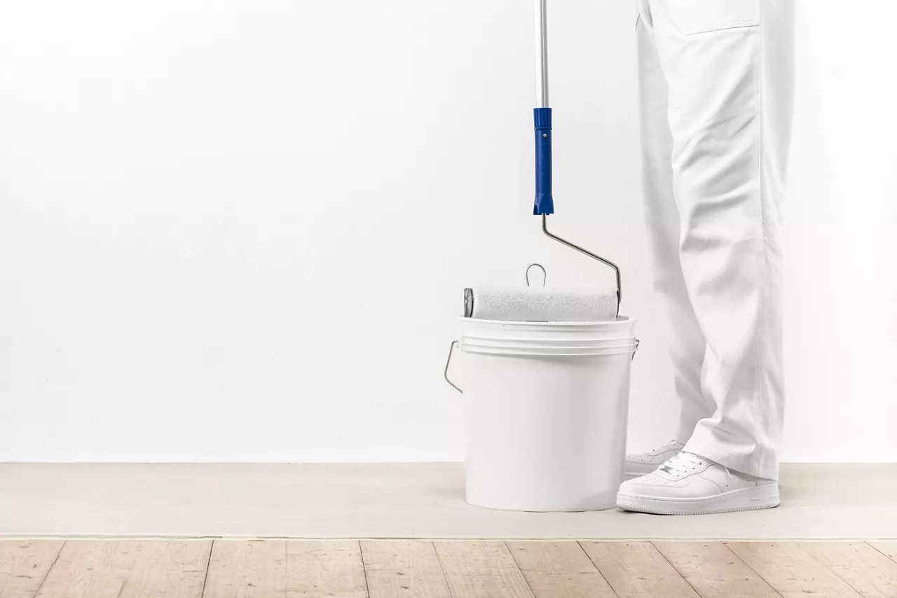 Painter with paint roller and bucket