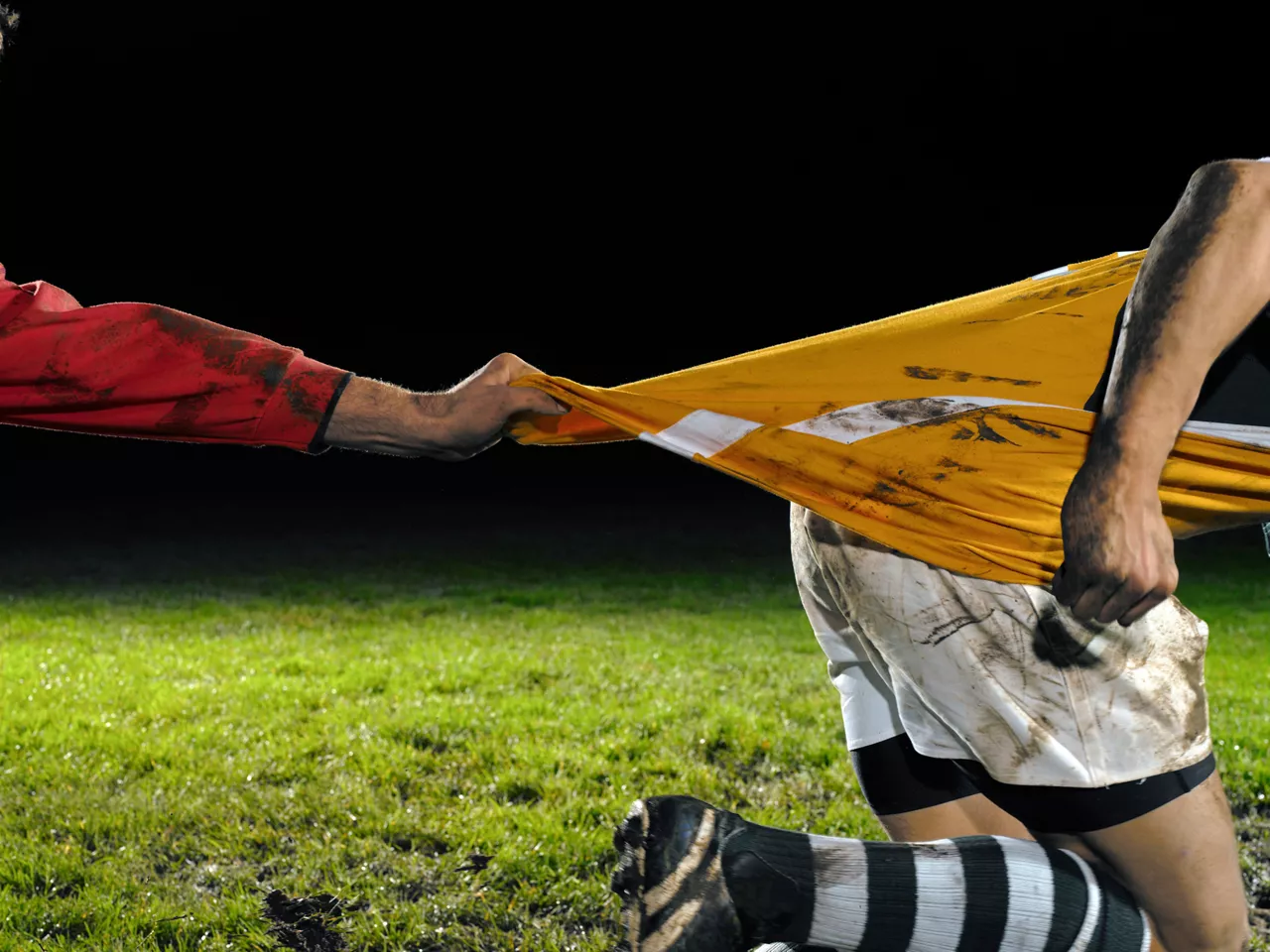 Two opposing rugby players with dirt stains 