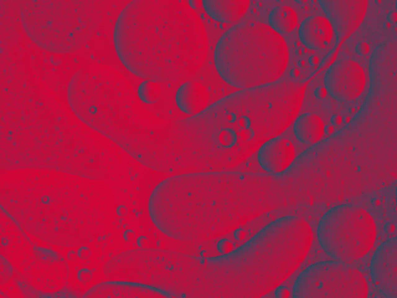 Full frame of the textures formed by the bubbles and drops of oil in the shape of circle floating on a gray and yellow colors background - red texture