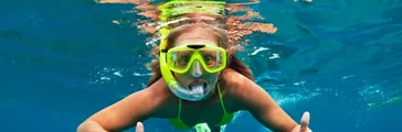 Girl snorkeling wearing rubber mask