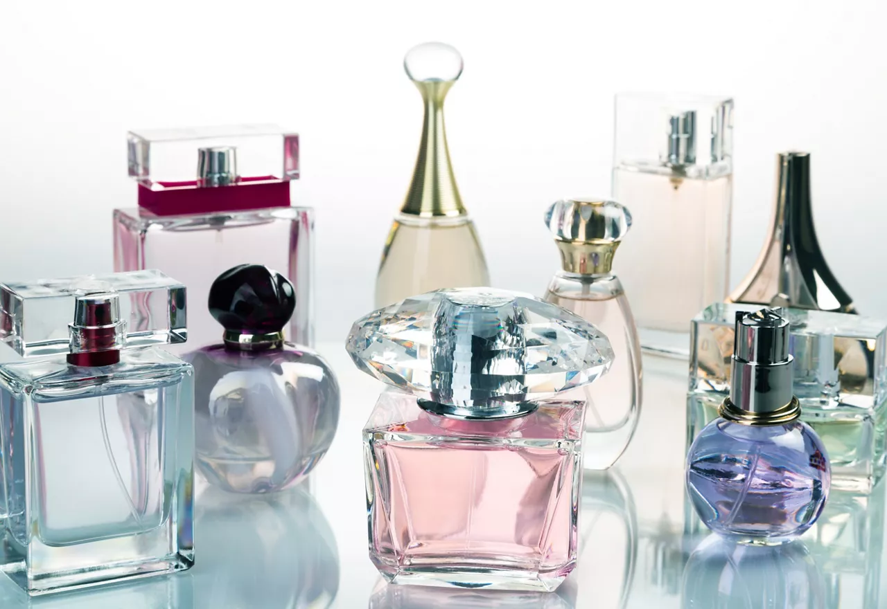 Glass perfume bottles presented on glass table.
