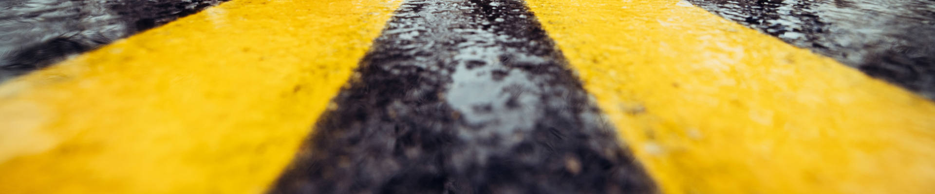 ウェットアスファルトの黄色の道路標示