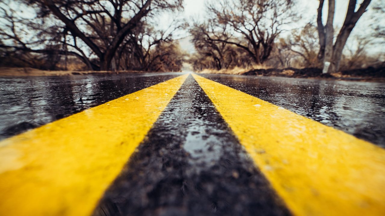 marca de carretera amarilla en asfalto húmedo