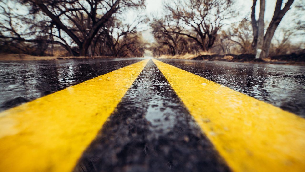 yellow road marking on wet asphalt