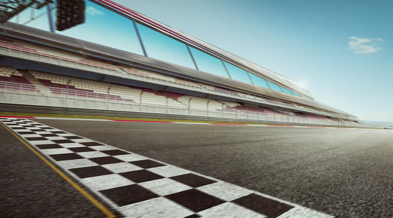 Wide angle view empty asphalt international racetrack with start and finish line, motion blur effect apply.