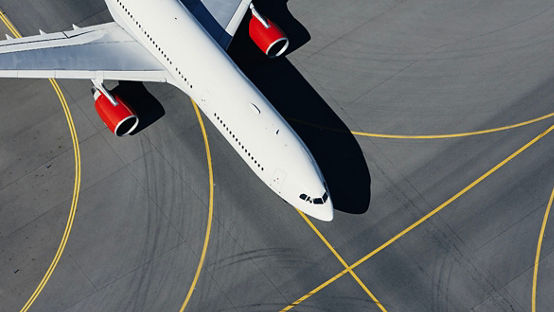 Aerial view of plane at airport. Airplane taxiing to runway before takeoff.
