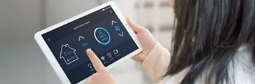Woman control temperature in living room with smart home control app on tablet