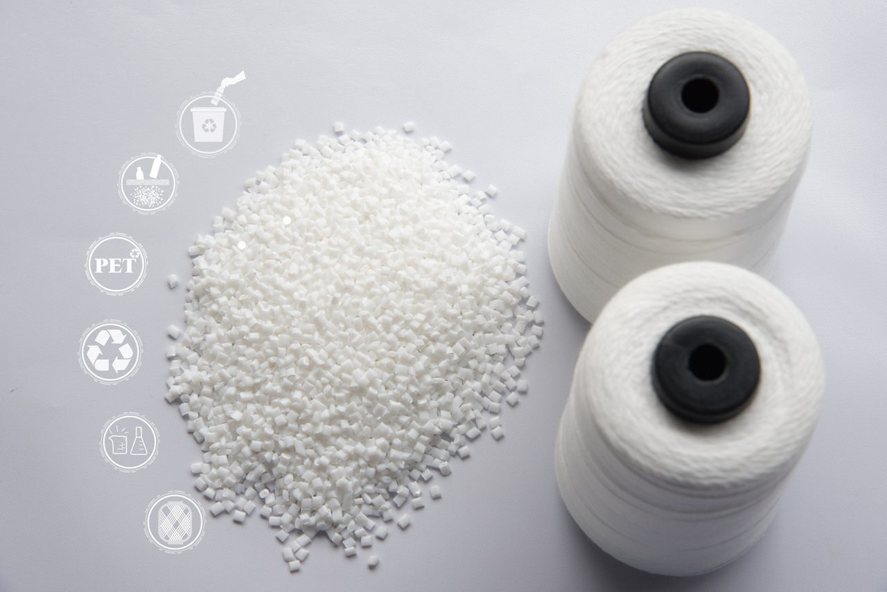 Chips de animais de estimação brancos Semi opacos, reciclagem de chips PET, chips de poliéster PET e carretel de fio FDY de poliéster branco bruto com fundo branco. Ícone de reciclagem, ícone sustentável e ícone de frasco.Conceito químico.