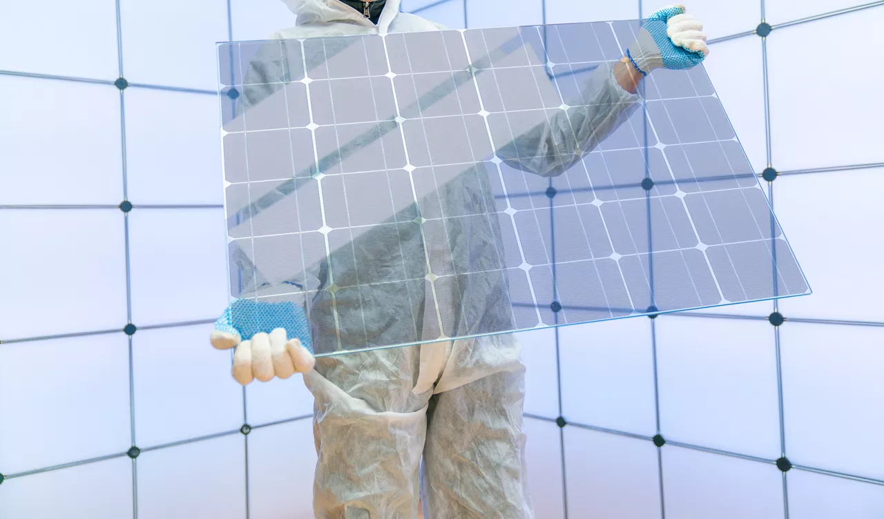 Translucent solar panels for use as window glass. Photovoltaic glass is  most cutting-edge new solar panel technology that   scope of solar. Transparent solar panel in the hands of a worker